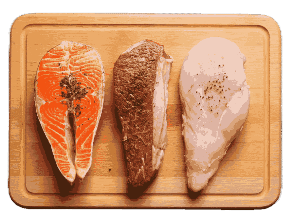 Wooden board with steak, chicken breast, and fish fillet